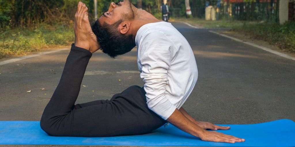A man sitting on a blue mat in the middle of the road