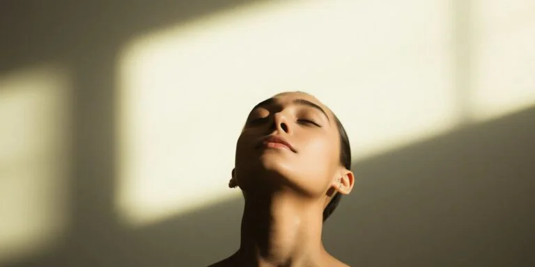 Person peacefully exhaling, eyes closed.